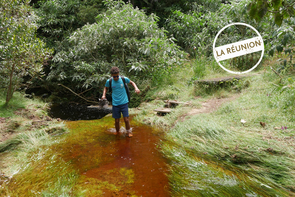 In der Regenzeit sind Wanderungen auf La Réunion besonders abenteuerlich: Elias Aguigah watet durch einen überschwemmten Wanderweg.