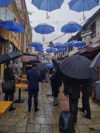 Ein verregneter Spaziergang durch die Altstadt Skopjes, mit einem Himmel aus EU-Regenschirmen.