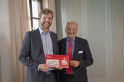 Robert Wöstenfeld (l.) vom Team Mathelino nahm von Peter Lange, Vorsitzender der Ernst-Reuter-Gesellschaft (r.), den ersten Preis der Kategorie Cultural & Social entgegen.