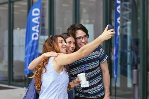 Selfie dreier DAAD-Stipendiatinnen vor dem Henry-Ford-Bau der Freien Universität.