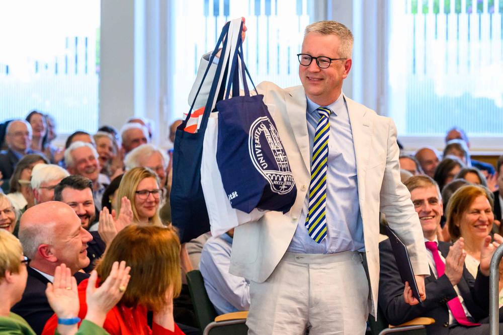 75 Schweizer Geschenke für die Freie Universität: Universitätspräsident und Mathematik-Professor Günter M. Ziegler freut sich über die Mitbringsel seines Kollegen von der Uni Zürich.