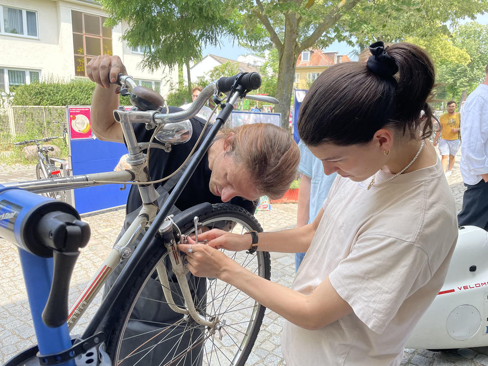 Reparieren statt neu kaufen: Politikstudentin Anthea schraubt mit Jeremias am Stand von FURad an ihrem Fahrrad.