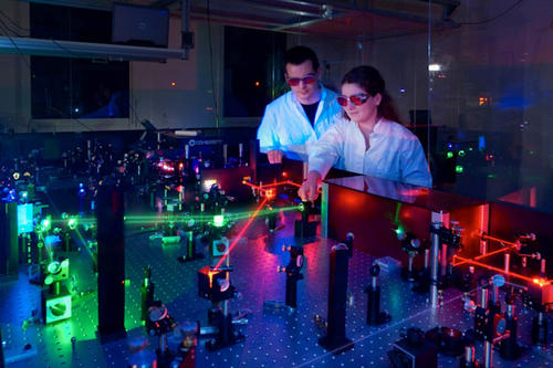 Mit Hilfe des Lasersystems kann Christian Eickhoff (links) unterschiedliche Photonenenergien erzeugen: Der Wellenlängenbereich deckt beinahe das gesamte Spektrum vom Infrarot- bis in den UV-Bereich ab.