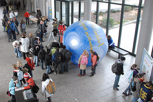Schülerinnen und Schüler blasen den Klimaballon auf.
