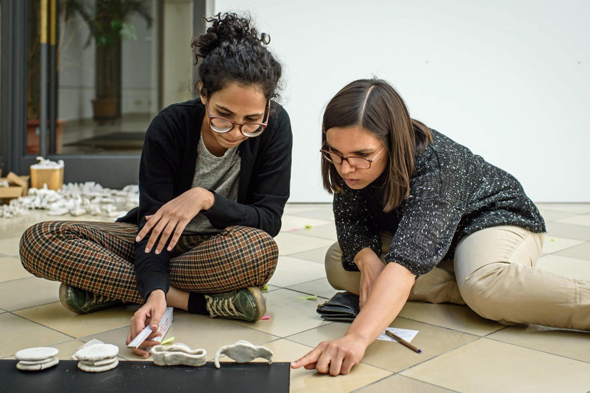 Die Künstlerin Poonam Jain (li.) mit Rebecca John (re.) von der Kleinen Humboldt-Galerie beim Aufbau der Ausstellung.