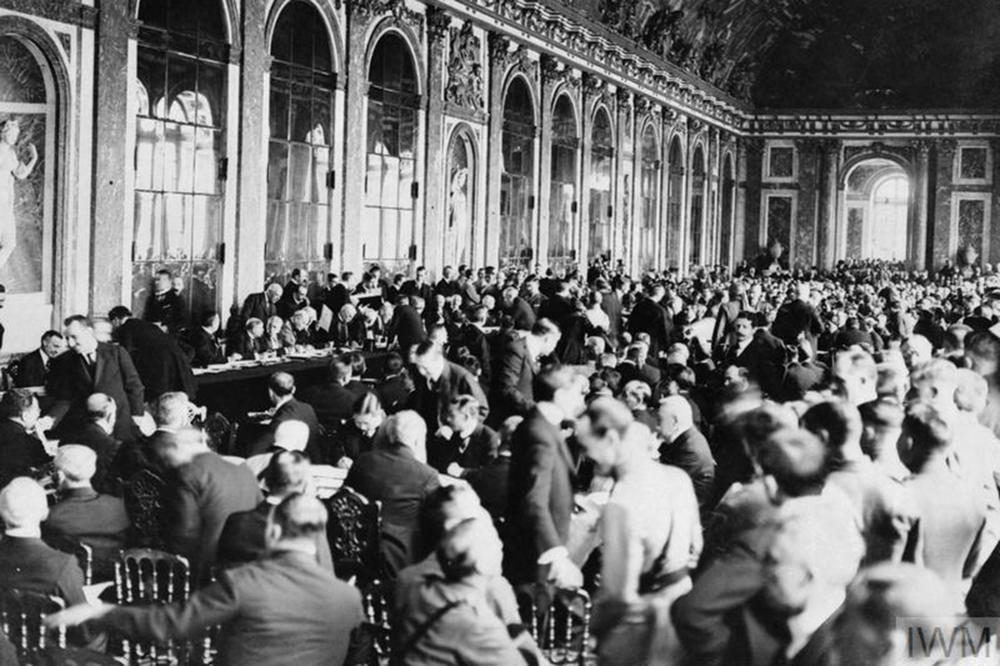 Der amerikanische Präsident Woodrow Wilson unterzeichnet den Friedensvertrag von Versailles am 28. Juni 1919 in der Spiegelgalerie des Schlosses von Versailles.