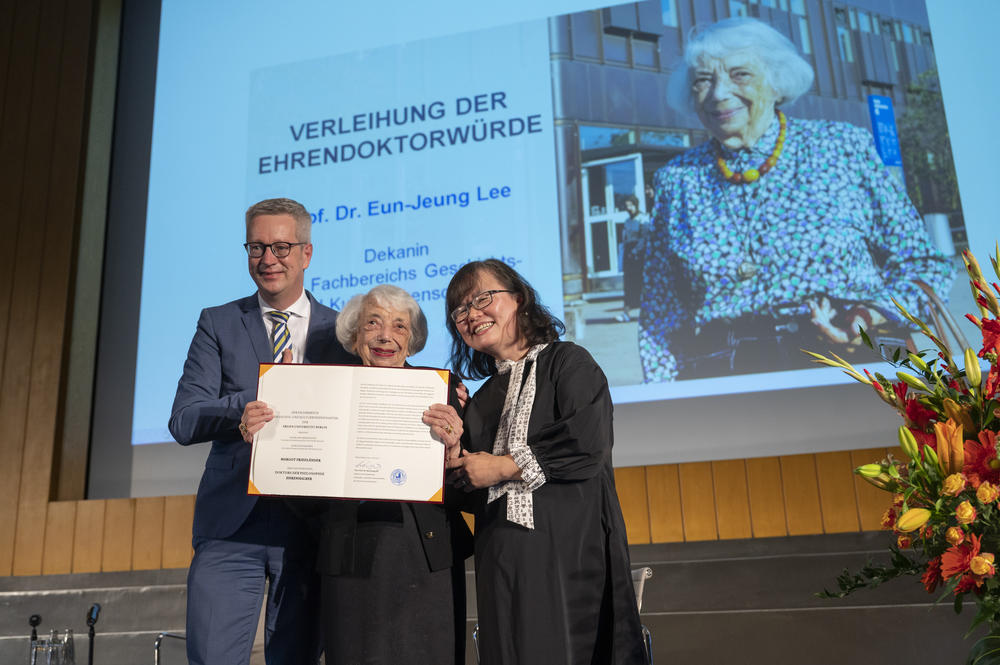 Margot Friedländer is standing between the president of the university Prof. Dr. Günter M. Ziegler (left) and the dean of the Department of History and Cultural Studies Prof. Dr. Eun-Jeung Lee, who presented her with the honorary doctorate document.