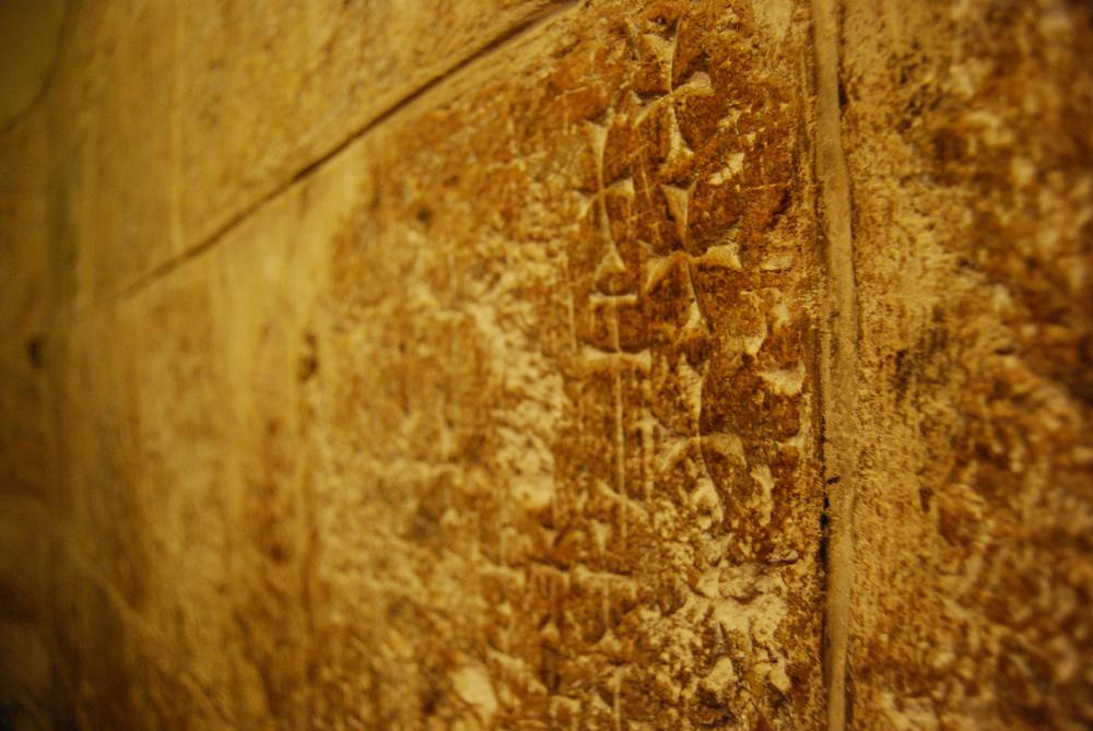 The walls at the entrance to the Chapel of Saint Helena in the Church of the Holy Sepulchre are covered with crosses that pilgrims have been carving there for centuries.