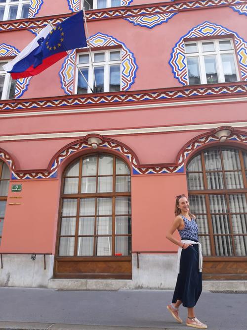 Sonja Poschenrieder in front of the flags of Slovenia and the European Union.
