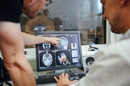 Two researchers from the Center for Cognitive Neuroscience Berlin analyze brain images in the MRI control room. They use images like this as measurements to study the structure of the brain.