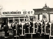 Many students from Freie Universität are hired through Heinzelmännchen to work as Santa Claus. Here, a group of them is promoting the job in front of Brandenburg Gate. The photo was taken around 1988.