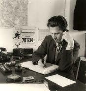 Berlin, 1949 – Many students finance their studies through part-time jobs. Heinzelmännchen is a placement service for such arrangements. Here a student is shown answering the phone in the main office of Heinzelmännchen.