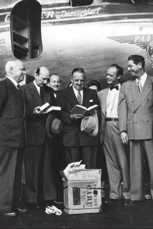 Auf dem Flughafen Tempelhof übergibt Paul G. Hoffman, Präsident der Ford Foundatation, dem Rektor der Freien Universität, Freiherr von Kreß, die erste Sendung von 20.000 Büchern, die die American Brotherhood insgesamt sammeln wird.