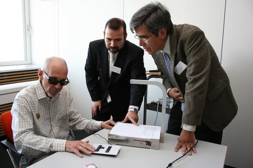 Norbert Zillmann (links) testet das Vorlesegerät für Blinde, das Dr. Pablo Vidales von den Telekom Laboratories und Professor Raúl Rojas (rechts) von der Freien Universität Berlin entwickelt haben.