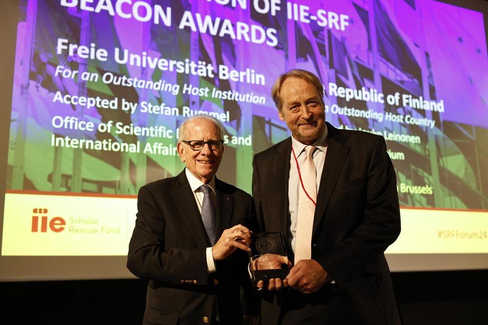 Den Preis nahm Dr. Stefan Rummel (r.), der Leiter des Referats Wissenschaftsbeziehungen, – stellvertretend für alle Beteiligten und alle Mentorinnen und Mentoren des Programms an der Universität – entgegen.