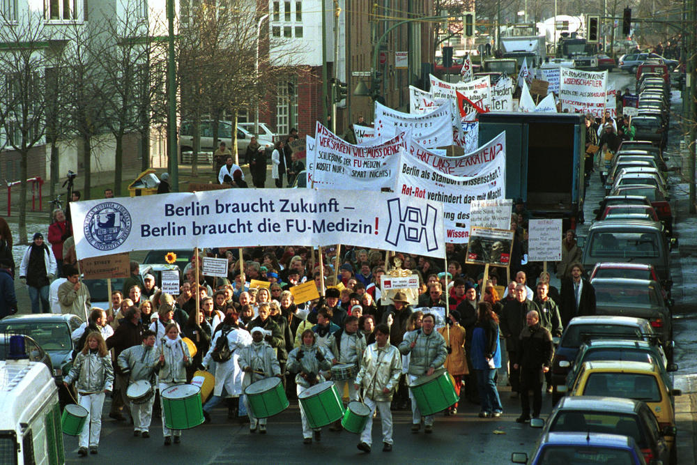 „Berlin braucht Zukunft, Berlin braucht Wissenschaft, Berlin braucht die FU-Medizin“ – unter diesem Motto finden 2002 massive Proteste statt, um das Uniklinikum Benjamin Franklin als Lehr- und Forschungsklinikum zu erhalten.