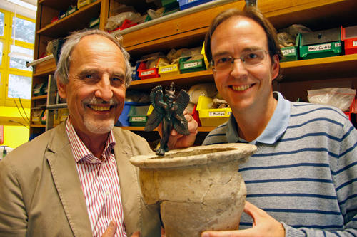 Inmitten ihrer Funde: Grabungsleiter Hartmut Kühne (li.) und sein MItarbeiter Janoscha Kreppner mit einer Dämonenfigur und einem Keramikgefäß.