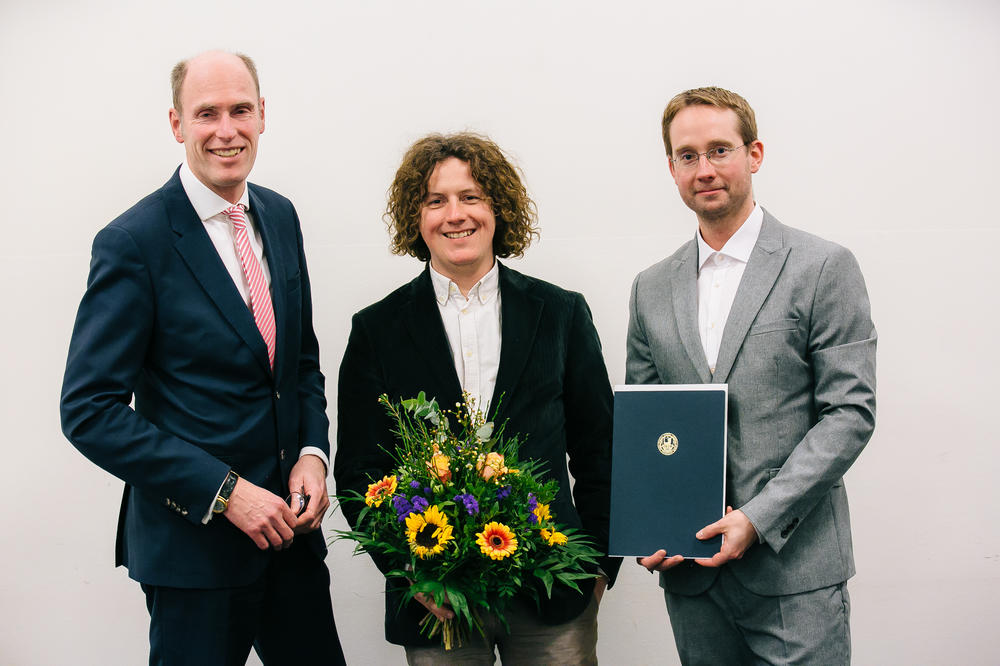 Die Preisverleihung: Ulf Tölch (Mitte) und Professor Dirk Ostwald (rechts) mit dem Präsidenten der Freien Universität, Professor Peter-André Alt (links).