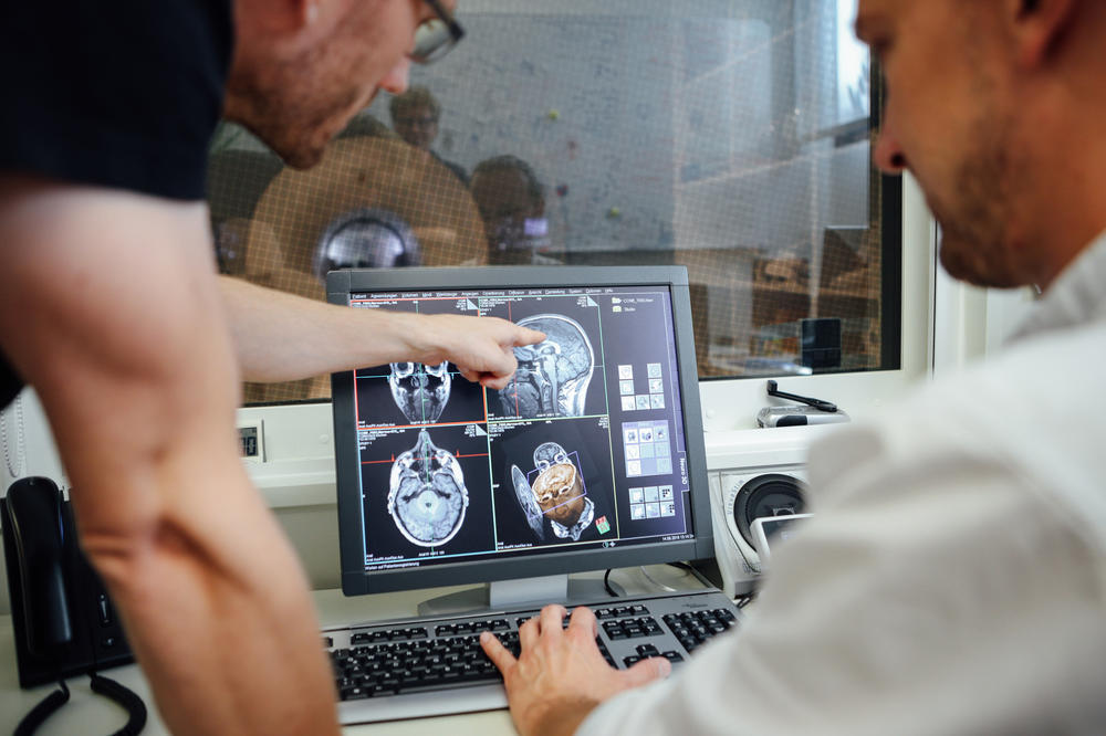 Zwei Forscher des Center for Cognitive Neuroscience Berlin sichten im Kontrollraum des Scanners des Magnetresonanztomografen ananotmische Aufnahmen. Solche Bilder werden bei nahezu jeder Messung erstellt, um die Struktur des Gehirns zu untersuchen.