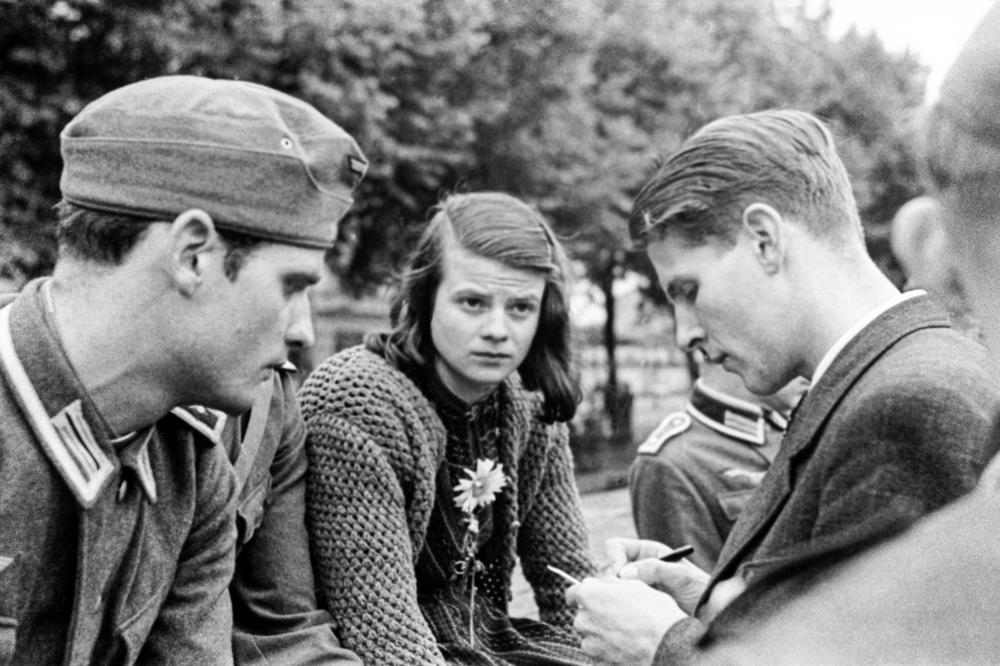 Mitglieder der Weißen Rose. Sophie Scholl zwischen ihrem Bruder Hans Scholl (links) und Christoph Probst. Die Aufnahme zeigt die Studentin und die Studenten am 22. Juli 1942 bei der Militärsammelstelle am Ostbahnhof München.