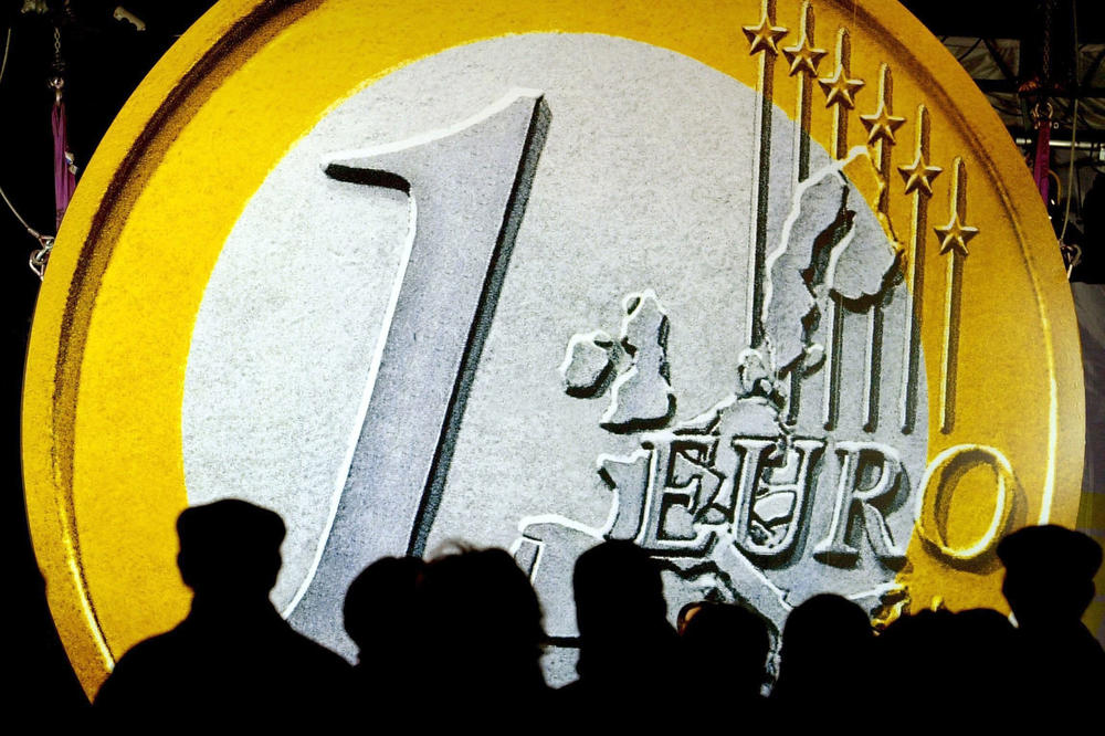 Eine riesige Münze überragt am Morgen des 17. Dezember 2001 die Menschen in der Innenstadt von Frankfurt. Hier wurden die ersten Tütchen mit einem Sortiment von Euro-Münzen verkauft.