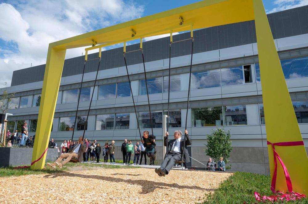 Die SupraSwing von Künstlerin Katja Marie Voigt steht neben dem neuen Forschungsbau SupraFAB. Chemieprofessor Rainer Haag (re.), Physikprofessorin Stephanie Reich (Mitte) und Peter Lange (li.), ehemals Kanzler der FU, weihten die Schaukel ein.