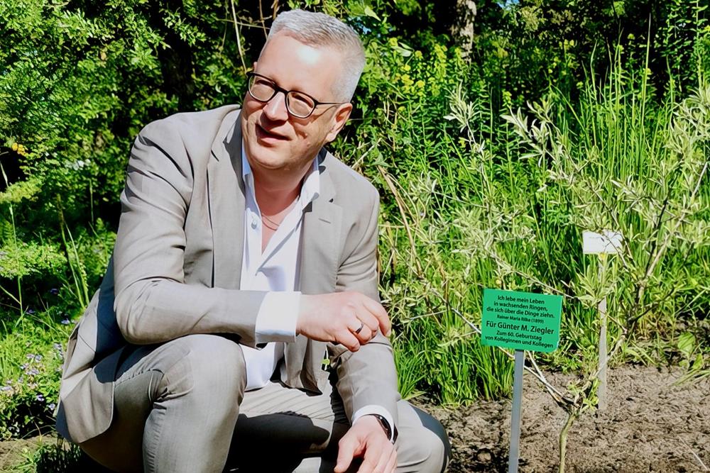 Günter M. Ziegler im Botanischen Garten. Seit Mai 2023 hat er dort die Patenschaft für ein Bäumchen – ein Geschenk von Kolleginnen und Kollegen.