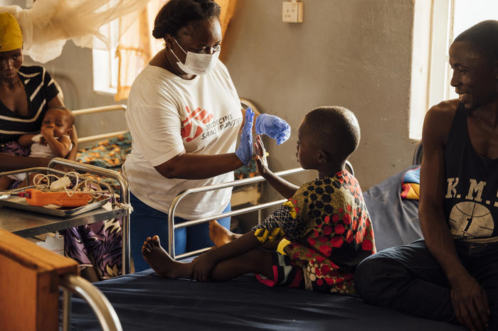 Regina Sandy, MSF nursing team leader, high-fives a recovering patient. The boy was treated in the pediatric department of Magburaka District Hospital, which is supported by MSF.